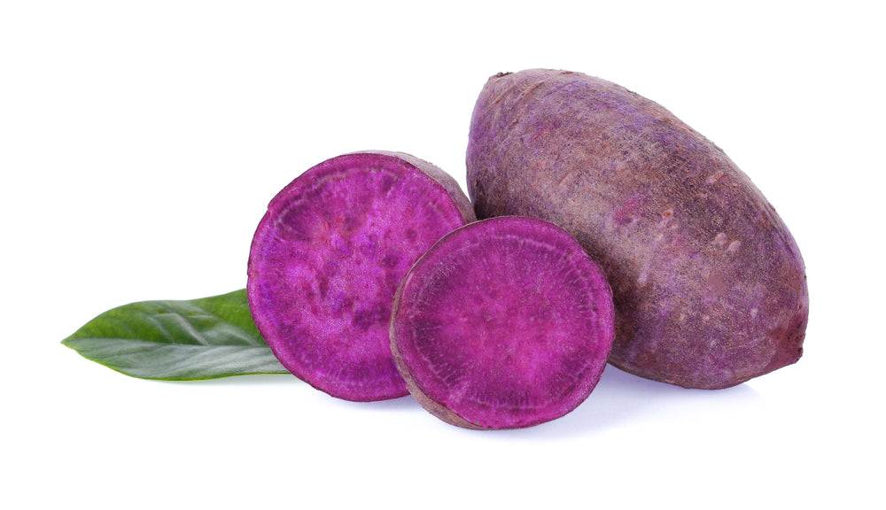 Two purple sweet potatoes and a leaf.