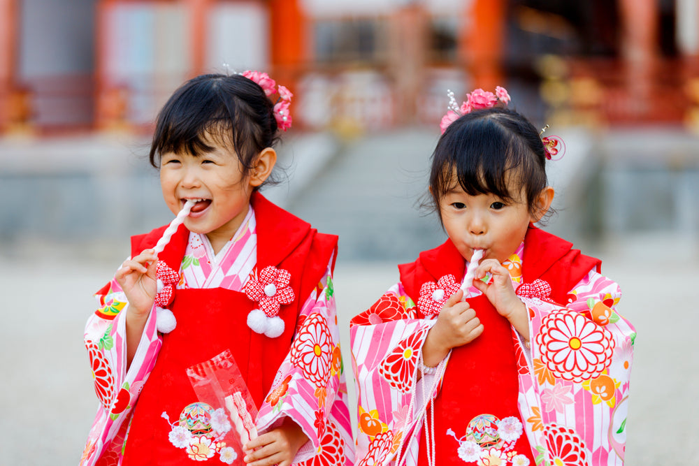 Two children in kimono enjoying chitose-ame