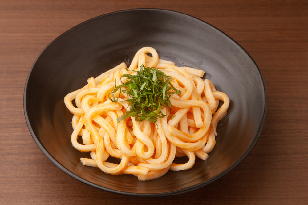 A bowl of mentaiko udon topped with seaweed.